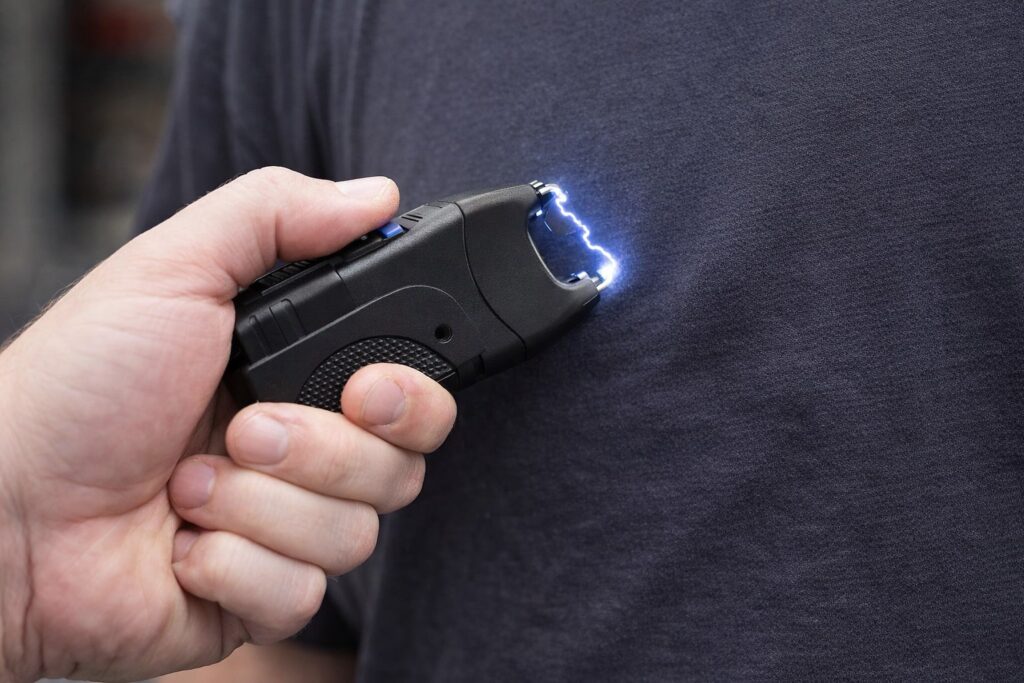 Image Title Hand holding a stun gun in direct contact for a stun gun vs Taser comparison