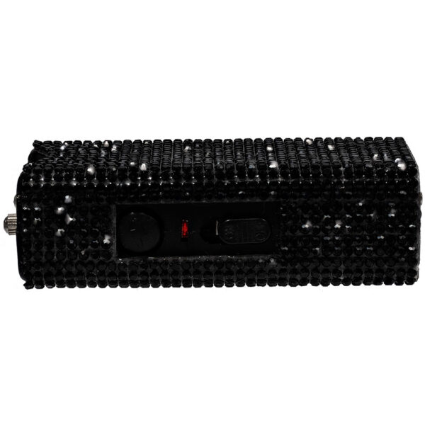 The image shows a compact, rectangular power bank adorned with black rhinestones covering its entire surface, giving it a sparkling, luxurious appearance. The power bank features a visible control panel with a switch and indicator light on one side, adding functionality to its aesthetic design. The textured rhinestone surface enhances grip and offers a fashionable accessory for tech-savvy users.