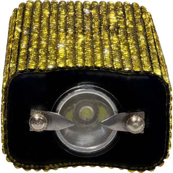 The image features a rectangular flashlight with a decorative design. The body of the flashlight is covered with rows of small, yellow rhinestones, giving it a sparkling appearance. The rhinestones are evenly spaced, creating a textured, glamorous look. The front of the flashlight displays a circular lens, indicating its purpose as an illumination device. The lens is set in