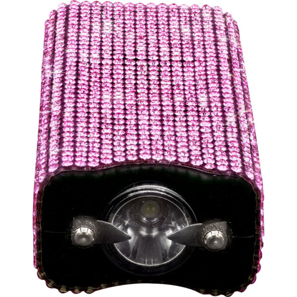 This image showcases a rectangular, compact flashlight adorned with a sparkling pink rhinestone exterior. The surface is covered in a pattern of glittering rhinestones, creating a luxurious and eye-catching appearance. The front of the flashlight is visible, featuring a central lens flanked by two switches or buttons, likely for operating the light. The design gives off a fashionable