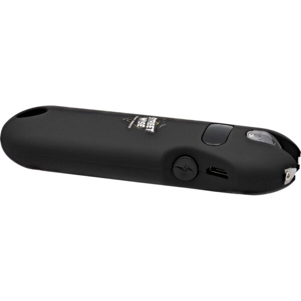 This image features a compact black electronic device, identifiable as a stun gun due to the visible prongs at one end. The device has a smooth, matte finish with a sleek design. A small button with a lightning bolt symbol is situated on the side, likely serving as an activation switch. Above the button, there is a USB charging port, indicating