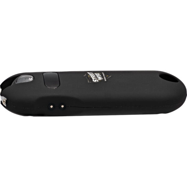 The image displays a black personal protection device, specifically a compact stun gun. The device features a sleek, oval design with a smooth, matte finish. On the top side, there is a visible button, likely used for activation. The device also includes a safety switch and a small charging port. Near the bottom, two metal contact points are visible,