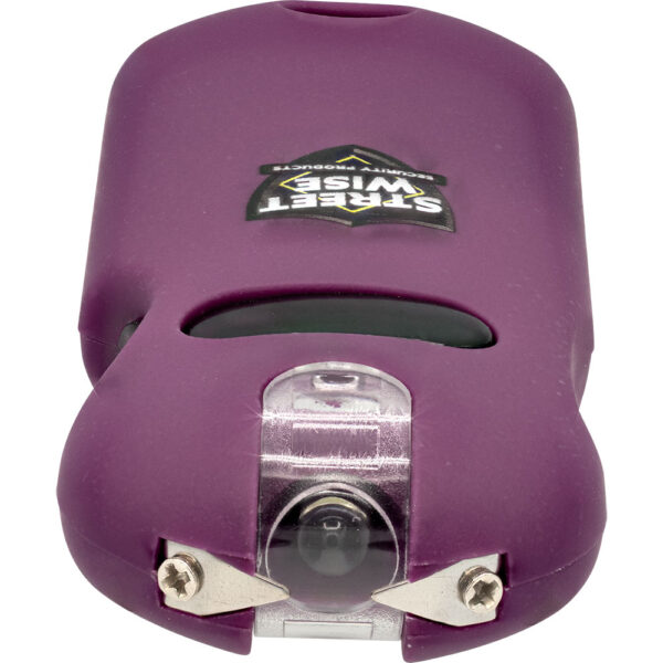 The image shows a close-up of a compact personal safety alarm device with a sleek, ergonomic design. It is primarily purple in color. Central on the top is a logo that reads Streetwise Security Products, and the branding appears to be in the shape of a badge, emphasizing its security purpose. The front features a prominent, clear plastic section,