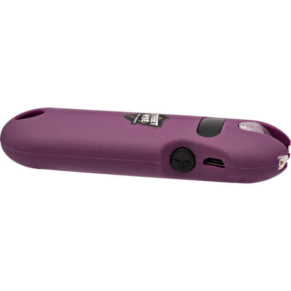 The image depicts a compact, handheld electronic device with a sleek, purple finish. The device appears to be a multipurpose tool featuring various functional elements. Notably, it includes a small, circular button with a lightning bolt icon, indicating it may have an electric or battery-operated component. A micro USB port is also visible, suggesting it is rechargeable.