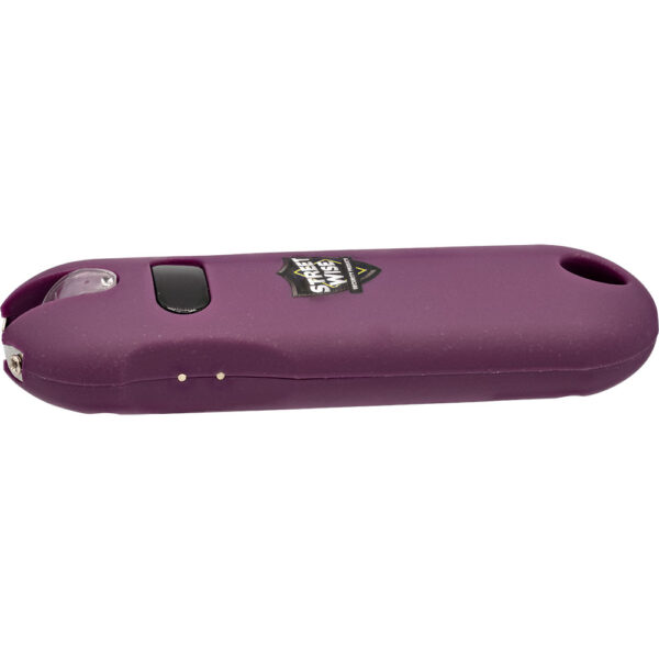 The image shows a compact, purple self-defense stun gun with a sleek, oval design. It features a matte finish for easy grip and includes a visible black button on the side for activation. At one end, there's a pronged metal tip used for delivering an electric shock, while the opposite end has a hole for attaching a keychain or lany