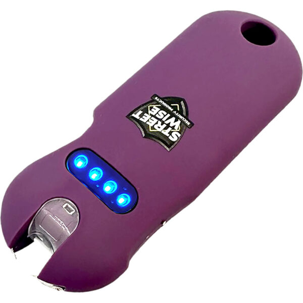 This image features a purple self-defense stun gun with a rounded design. The device prominently displays a logo with the text Street Wise on its surface. It has a sleek, compact form suitable for personal security. The front part shows four illuminated blue LED lights, indicating power or charge status. The design includes metallic prongs at one end, characteristic