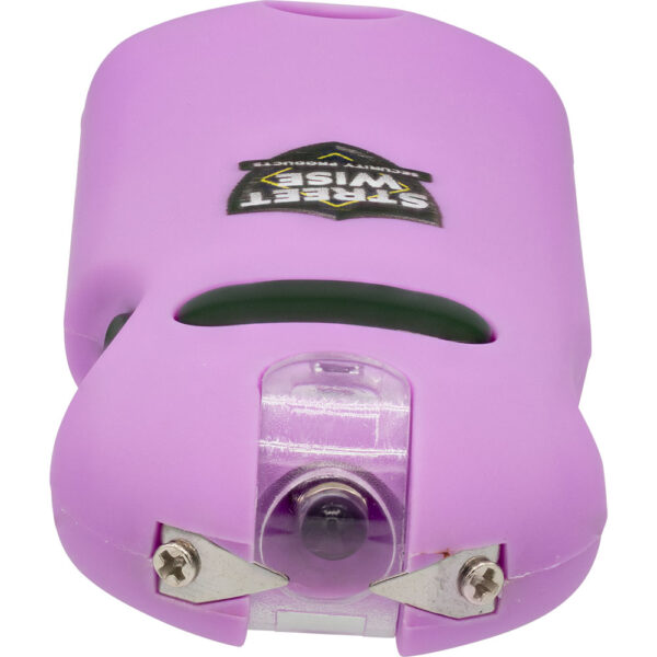 The image features a pink personal safety device with a compact, ergonomic design. The device includes a powerful stun gun feature, indicated by the two visible metal prongs on one end. It has a central button and a clear plastic panel, possibly housing a flashlight or LED indicator. The surface of the device is branded with a logo featuring the words Street