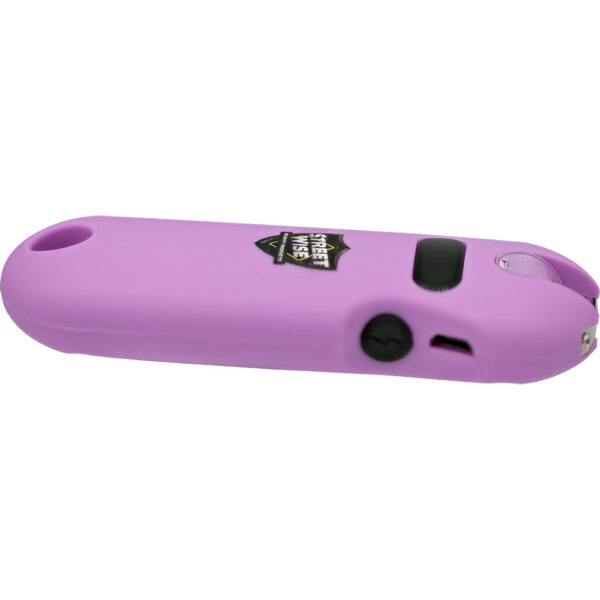 The image features a purple handheld device, specifically a stun gun, designed for personal self-defense. The body is a sleek, ergonomic design with a rounded tip and smooth surface. In the center, a logo reading Street Wise is visible in a shield shape. The device includes a black button, likely for activation, and a small opening for a