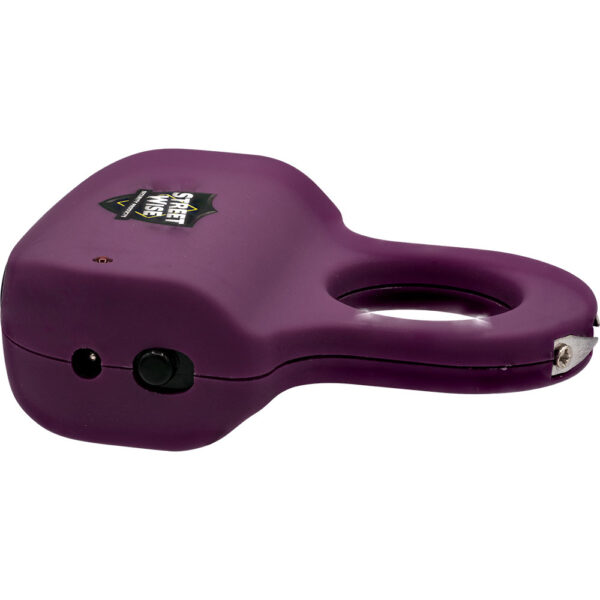 The image features a compact, dark purple personal safety device with a unique design. It includes a large loop handle for easy gripping and portability. The device is labeled with the Street Wise brand logo on the side. A small button and charging port, as well as a metal tip, are visible on the side, suggesting functionality related to stun or